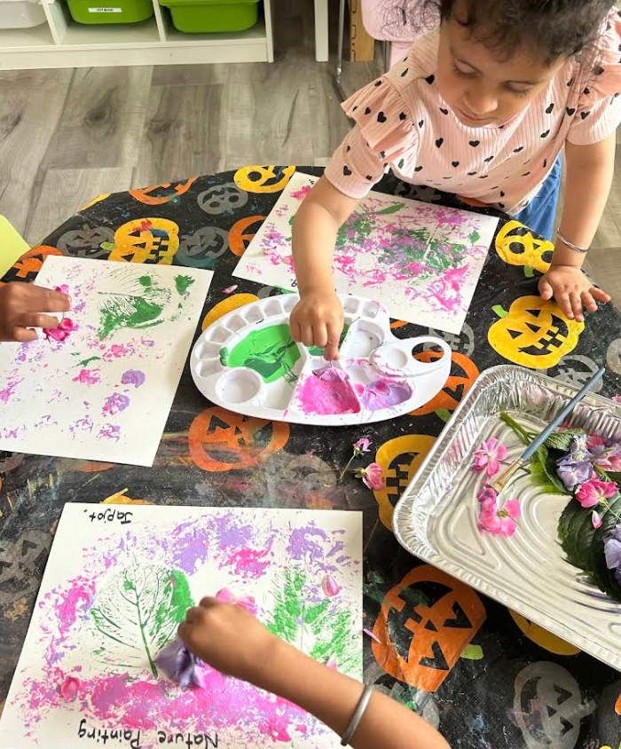 Children making nature prints with leaves and flowers